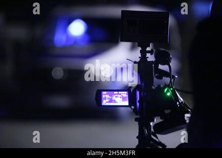 Aschersleben, Germania. 10 novembre 2021. Le forze di polizia corrono fuori da una scena di sospetto crimine, mentre un veicolo di polizia può essere visto sullo schermo di una macchina fotografica. Il corpo di una ragazza mancante di 14 anni è stato trovato ad Aschersleben. Credit: dpa/dpa-Zentralbild/dpa/Alamy Live News Foto Stock