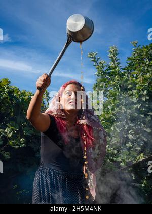 Ankara, Turchia - Settembre 18 2021: La melassa viene prodotta facendo bollire l'uva alle alte temperature nei cavoldri. La donna produce melassa (pekmez in turco). Foto Stock