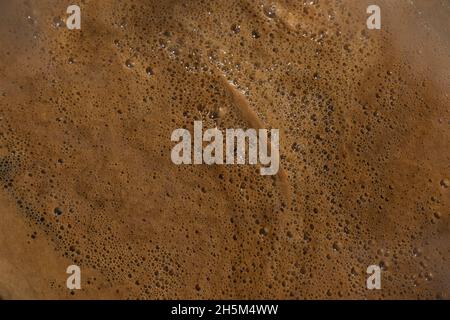 Superficie del caffè caldo lucida e schiumosa. Melassa lucida (pekmez in turco) di fondo texture. Foto Stock