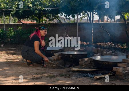 Ankara, Turchia - Settembre 18 2021: La melassa viene prodotta facendo bollire l'uva alle alte temperature nei cavoldri. La donna produce melassa (pekmez in turco). Foto Stock