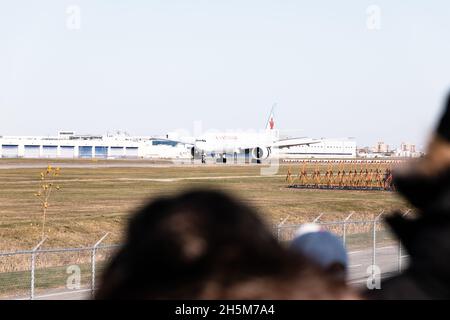 Persone che guardano un Air Canada Boeing 777-333 a Montreal Airport, Pierre-Elliott Trudeau, Quebec, Canada Foto Stock