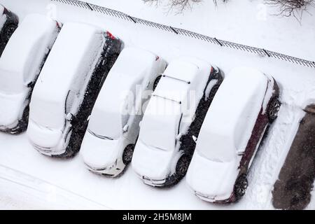 Linea da autovetture coperte di neve, parcheggio esterno, vista dall'alto Foto Stock