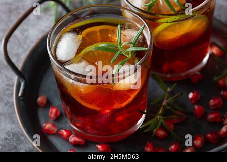 Cocktail di melograno decorato con lime, rosmarino e ghiaccio, bevanda fredda Foto Stock