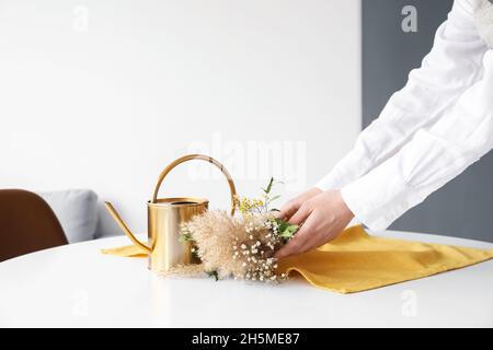 Donna che prende il bouquet di bei fiori secchi dal tavolo, primo piano Foto Stock