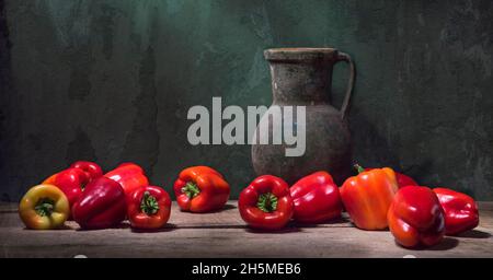 Ancora vita con paprika campana rossa e una grande caraffa antica sullo sfondo di una parete incrinata Foto Stock