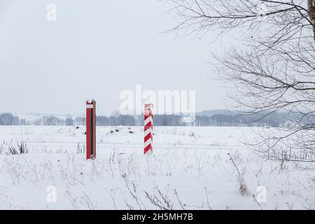 Pilastri di confine di Bielorussia e Polonia al confine in un campo invernale Foto Stock