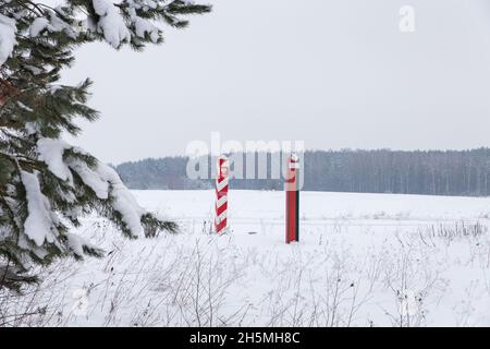 Pilastri di confine di Bielorussia e Polonia al confine in un campo invernale Foto Stock