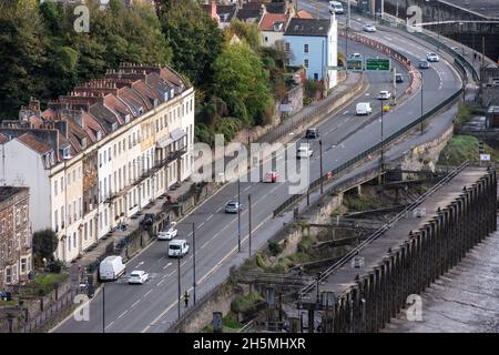 Il traffico passa attraverso le case della città di Hotwells sulla trafficata A4 Portway a Bristol. Foto Stock