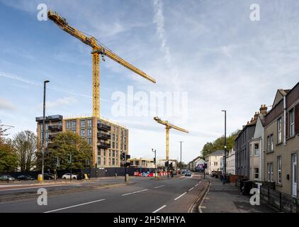 Le gru a torre si innalzano sopra il cantiere di costruzione di edifici di appartamenti a Totterdown raggiungere la Bath Road di Bristol. Foto Stock