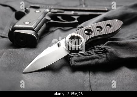 Coltello tascabile pieghevole con pistola su sfondo nero Foto Stock