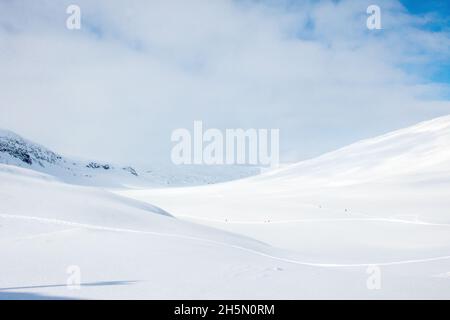 Minuscoli sciatori sulla strada per il passo di Tjaktja, sentiero Kungsleden tra Abisko e Nikkaluokta, aprile 2021 Foto Stock