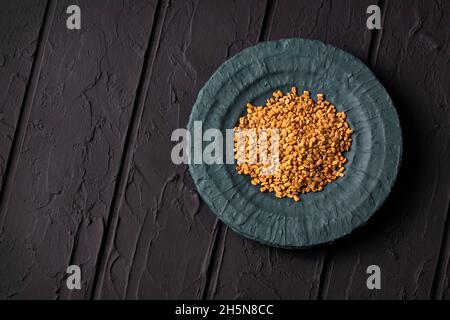 Semi di fenugreek nella ciotola di legno - spazio di testo Foto Stock