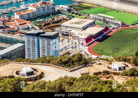 Vista della città di Gibilterra dalla Rocca di Gibilterra con pistole d'artiglieria e campo da calcio in primo piano Foto Stock