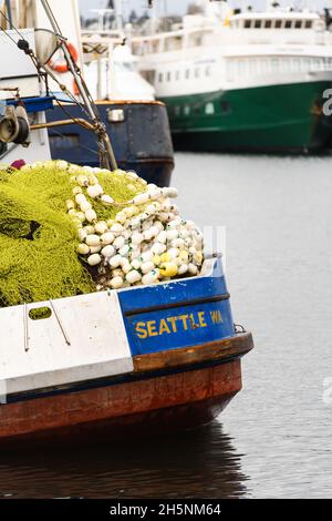 Seattle - 09 novembre 2021; una barca da pesca con Seattle WA in oro su blu a poppa. Le reti da pesca e i galleggianti sono impilati in alto sulla nave Foto Stock