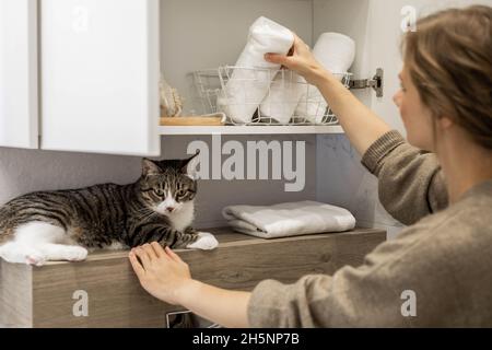 Donna che mette ordinatamente o mostra un pulito arrotolato asciugamani bianchi in cotone biologico. Foto Stock