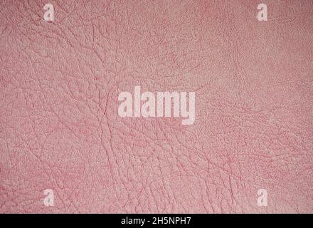 Un frammento di vera pelle con rughe e pieghe, tinto artificialmente rosa pallido. Sfondo, motivo, trama. Foto Stock