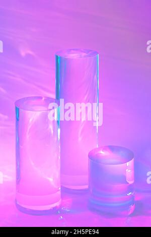 tre podi in vetro chiaro su sfondo rosa pastello Foto Stock