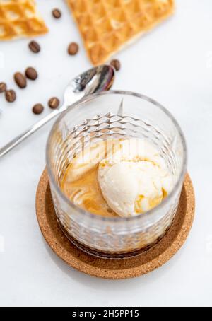 Caffè Affogato con gelato alla vaniglia in vetro cristallo su tavolo di marmo bianco Foto Stock