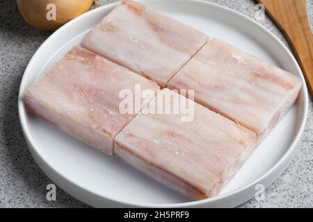 Piatto con pezzi di filetto di Pollock congelato come ingrediente per cucinare da vicino Foto Stock