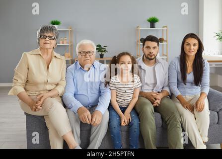 Famiglia multigenerazionale seduta sul divano a casa e guardare la televisione insieme Foto Stock