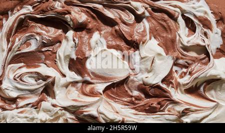 Doppio sapore di cioccolato e vaniglia gelato o gelato in un primo piano panorama trama di fondo sulla superficie del dessert per la pubblicità menu o. Foto Stock