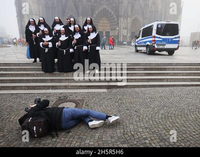 Colonia, Germania. 11 Nov 2021. I carnivalisti vestiti da monache hanno la loro foto scattata di fronte alla cattedrale. La nuova stagione di carnevale è iniziata nelle condizioni di Corona. Il 11.11. È celebrato quest'anno di nuovo in presenza. Credit: Oliver Berg/dpa/Alamy Live News Foto Stock