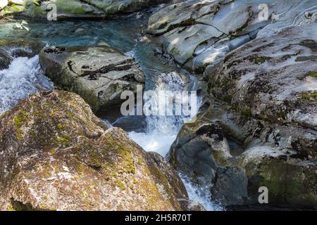 Un flusso che scompare in un imbuto. Nuova Zelanda. Ruscello tra le pietre. Isola del Sud Foto Stock