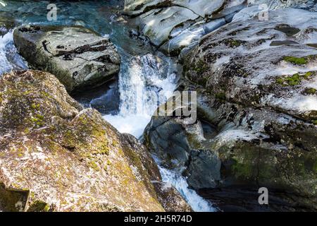 Un flusso che scompare in un imbuto. Asm. Imbuto Fiordland in Nuova Zelanda. Ruscello tra le pietre. Isola del Sud Foto Stock