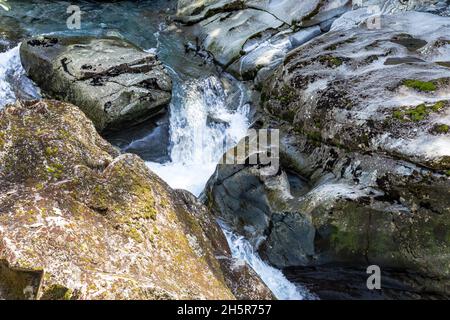 Parco Nazionale di Fiordland. Un flusso che scompare in un imbuto. Asm. Imbuto Ruscello tra le pietre. Nuova Zelanda. Foto Stock