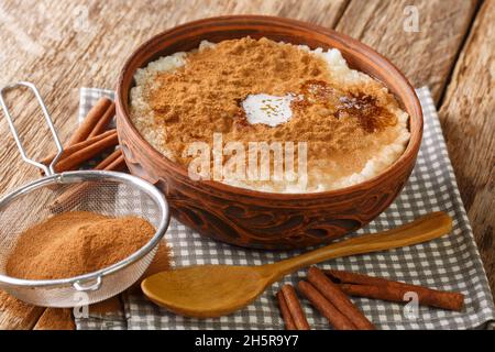 Budino di riso alla cannella da vicino nella ciotola sul tavolo. Orizzontale Foto Stock