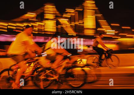 Astratto gruppo irriconoscibile astratto ciclisti, bici da corsa, città notturna, bokeh illuminazione, movimento sfocato. Sport, stile di vita sano, attività per il tempo libero Foto Stock