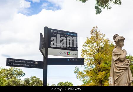 Un cartello per le attrazioni e una statua greca classica nel Royal Botanical Garden di Sydney, Australia. Foto Stock