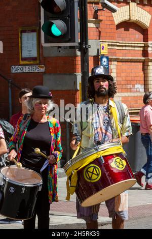 Immagine di strada che mostra la diversità in due membri di una dimostrazione climatica con la batteria. Immagine colorata che mostra anche il semaforo verde come simbolo. Foto Stock