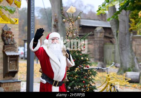 11 novembre 2021, Brandeburgo, Fürstenberg/Havel/OT Himmelpfort: Babbo Natale esce per una breve pausa dopo l'arrivo all'ufficio postale di Natale. Babbo Natale prevede di essere al suo ufficio postale di Natale da Venerdì a Domenica ogni fine settimana fino alla vigilia di Natale. Durante questo periodo, può essere visto attraverso la finestra di rispondere alla posta. Tuttavia, a causa della minaccia continua di infezione di Corona, il suo ufficio decorato a Natale non sarà aperto al pubblico per i visitatori di quest'anno. Foto: Soeren Stache/dpa Foto Stock