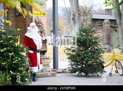 11 novembre 2021, Brandeburgo, Fürstenberg/Havel/OT Himmelpfort: Babbo Natale esce per una breve pausa dopo l'arrivo all'ufficio postale di Natale. Babbo Natale prevede di essere al suo ufficio postale di Natale da Venerdì a Domenica ogni fine settimana fino alla vigilia di Natale. Durante questo periodo, può essere visto attraverso la finestra di rispondere alla posta. Tuttavia, a causa della minaccia continua di infezione di Corona, il suo ufficio decorato a Natale non sarà aperto al pubblico per i visitatori di quest'anno. Foto: Soeren Stache/dpa Foto Stock