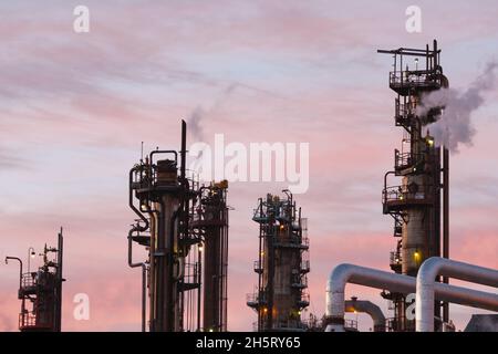 Vista delle tubazioni e delle torri di raffineria di petrolio. Foto Stock