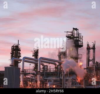 Vista delle tubazioni e delle torri di raffineria di petrolio. Foto Stock