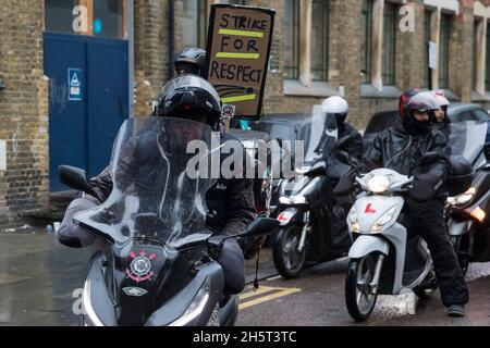 Londra, Regno Unito. 10 novembre 2021. Gli appassionati di consegna di cibo che fanno parte del sindacato Independent Workers of Great Britain (IWGB) prendono parte a un motade che porta al municipio di Hackney per richiedere un parcheggio gratuito e sicuro. I piloti hanno deciso di sciopero dopo essere stati costretti dalla direzione del ristorante e dalle autorità locali ad attendere gli ordini in un parcheggio più lontano dai ristoranti, in particolare il ramo Dalston di McDonalds, e senza servizi igienici o riparo. Credit: Mark Kerrison/Alamy Live News Foto Stock