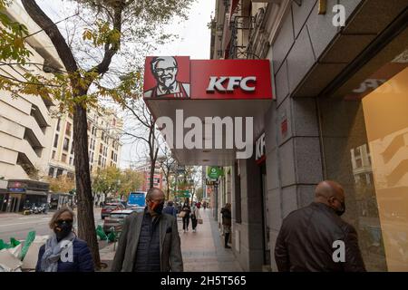Madrid, Spagna - Nov 25, 2020: Molte persone camminano di fronte al ristorante fast food, KFC, Kentucky Fried Chicken, situato in Goya Street Foto Stock