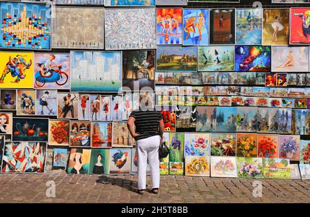 Cracovia. Cracovia. Poland.tourists guardando le immagini esposte in vendita nella galleria d'arte all'aperto sulle antiche mura della città. Foto Stock