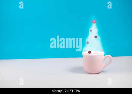 Albero di Natale con decorazione fatta di fumo di caffè. Su sfondo blu pastello. Concetto minimo astratto di vacanze invernali. Con spazio di copia. Foto Stock