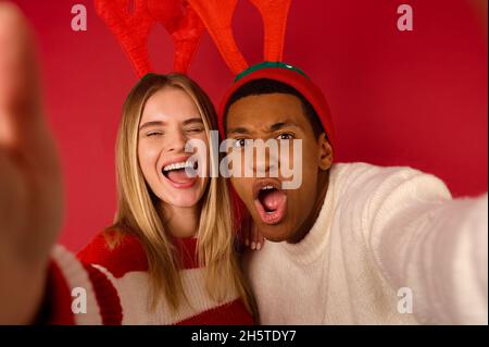 Una giovane coppia di cappelli con cornici che si divertono Foto Stock