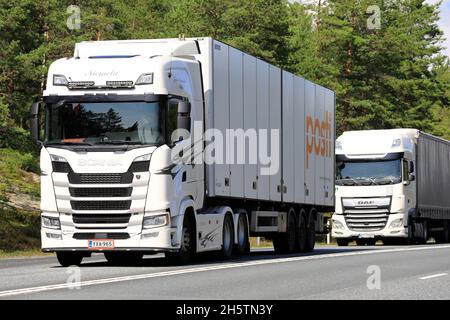 I veicoli semirimorchi bianchi Scania S500 e DAF XF trasportano merci sull'autostrada 3 direzione sud in estate. Ikaalinen, Finlandia. Agosto 12, 2021. Foto Stock