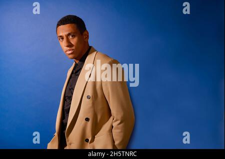 Un bel mulatto in un abito beige Foto Stock