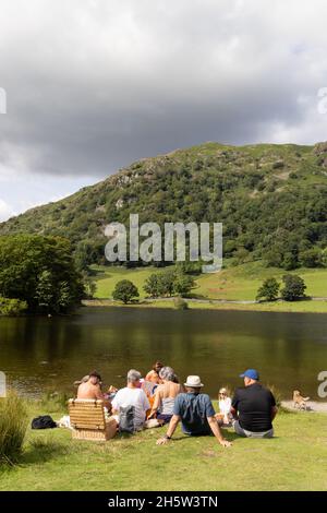 Picnic famiglia UK; famiglie che hanno un picnic sulle rive del lago d'acqua Rydal, in estate in vacanza, il Lake District, Cumbria UK Foto Stock