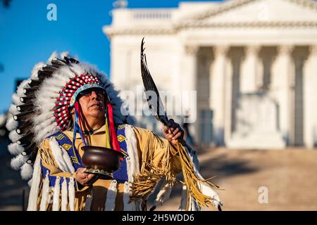 Arlington, Stati Uniti. 9 novembre 2021. Vincent Goesahead Jr. Della Crow Nation, esegue una cerimonia del piatto di smudge durante la Tomba della commemorazione del Centenario del Milite Ignoto al cimitero nazionale di Arlington, 9 novembre 2021 ad Arlington, Virginia. Credit: Elizabeth Fraser/DOD Photo/Alamy Live News Foto Stock