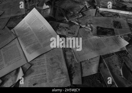 Vista dall'alto in scala di grigi di vecchi quotidiani polverosi sul pavimento Foto Stock