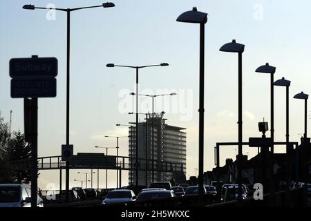 Traffico pesante sulla circonvallazione A3 con Tolworth Tower in silhouette al tramonto con traffico in prima serata. Foto Stock