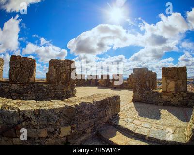 Mura e merlamenti del castello medievale di Trujillo in una giornata di cielo blu con le nuvole. Foto Stock