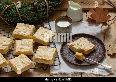 Fette di torta di mele con meringa servita con caffè. Stile rustico. Foto Stock